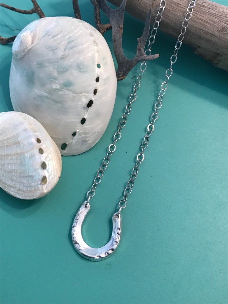 handcrafted Horseshoe is on a 18 1/2 inch textured Sterling silver chain.